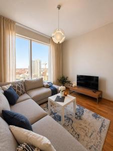 a living room with a couch and a tv at 13th Floor Cityview Luxury in Tallinn