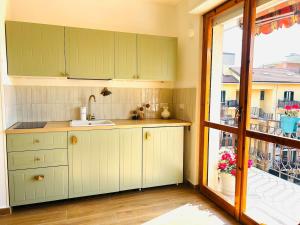a kitchen with green cabinets and a large window at Casa Marysol in Ventimiglia