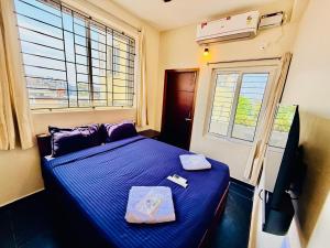a bedroom with a blue bed and a window at Villa Govindaraj in Pondicherry
