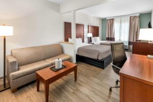 a hotel room with a bed and a couch at Quality Suites Waldorf in Waldorf +45 photos