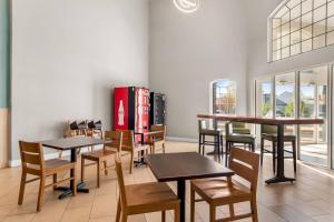 a restaurant with tables and chairs and a soda machine at Quality Suites Waldorf in Waldorf