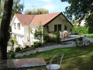 ein kleines weißes Haus mit einem Tisch im Hof in der Unterkunft Gîte d'Maïsala Les Mésanges in Heidwiller