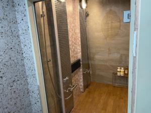 a bathroom with a shower with a glass door at ピンポンホテル Peace Park in Hiroshima +26 photos
