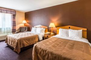 a hotel room with two beds and a chair at Quality Inn Killeen Near Fort Hood in Killeen