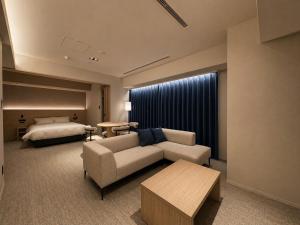 a hotel room with a couch and a bed at Randor Hotel Sapporo Heritage in Sapporo