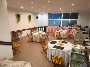 a restaurant with tables and chairs in a room at Hotel Vila Luena in Vila Verde