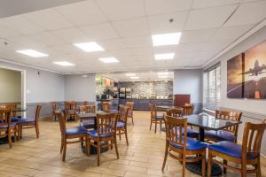 a dining room with tables and chairs and a bar at Quality Inn & Suites CVG Airport in Erlanger