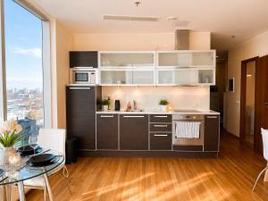 a kitchen with white cabinets and a table with a dining room at Panoramic Sea View -13th Floor in Tallinn