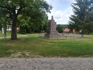 a monument in the middle of a grass field at Alte Schule Nausdorf in Lenzen