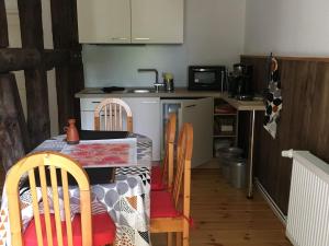 a kitchen with a table and chairs and a kitchen with a stove at Alte Schule Nausdorf in Lenzen