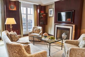 a living room with a fireplace and a tv at Hotel Adlon Kempinski Berlin in Berlin