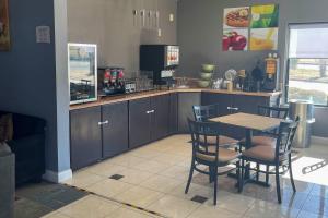 a kitchen with a table and chairs and a counter at Quality Suites Abilene Mall Area in Abilene