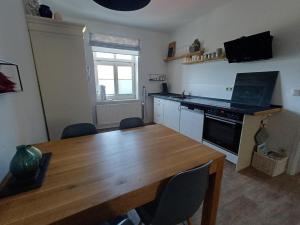 a kitchen with a wooden table and a wooden dining room table at Stadtapartement Geisa in Geisa