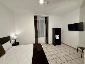 a hotel room with a bed and a flat screen tv at Hotel NASS del Sur in Cuenca