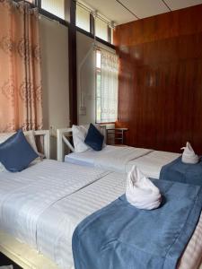 two beds with blue and white sheets in a room at Ladybugs hostel sunset in Taling Ngam Beach