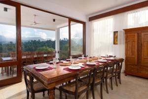 a dining room table with chairs and a large window at Villa Subashri, Victoria Golf Greens - Digana in Kandy