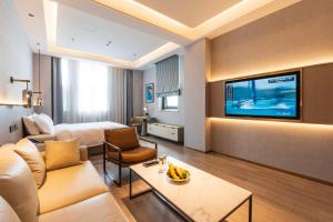 a hotel room with a bed and a television at JOY Hotel Hangzhou in Hangzhou