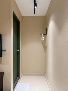 a bathroom with a green door and a towel on the floor at Mansion Inn Sibu in Sibu