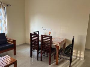 a dining room with a table and chairs and a couch at Chippy Residency Coorg in Gonikoppal