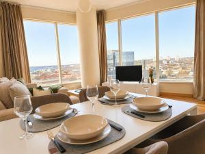 a dining room with a table with glasses and chairs at Panoramic Sea View -11th Floor in Tallinn