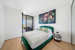 a bedroom with a bed with a green headboard at Stylish 1-Bed in CBD with Secure Underground Parking in Canberra