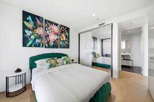 a bedroom with a large bed with a green headboard at Stylish 1-Bed in CBD with Secure Underground Parking in Canberra