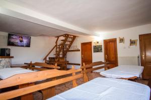 a room with two beds and a stair case at Pensiunea HEIDI in Vartop