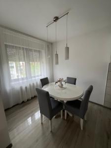 a dining room with a white table and chairs at Stan na dan Vrdnik in Vrdnik +7 photos