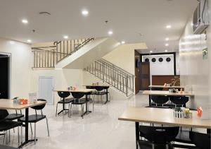 a restaurant with tables and chairs and a staircase at Cris Inn - Bayugan in Bayugan City