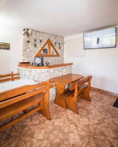a room with two benches and a stone wall at Pensiunea HEIDI in Vartop