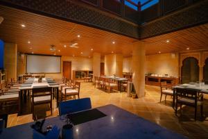 a large room with tables and chairs and a projection screen at Hotel Aurea Jaisalmer in Jaisalmer