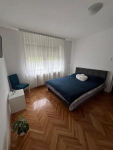 a bedroom with a bed and a wooden floor at Stan na dan Vrdnik in Vrdnik