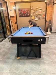 a man playing pool on a pool table at Hostel Friends Station & Cafe in Pattaya South