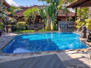 a swimming pool in a backyard with a house at Hotel Flamboyan Kuta in Kuta
