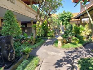 a garden path in front of a building at Hotel Flamboyan Kuta in Kuta