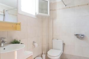 a white bathroom with a toilet and a sink at Apollo Sea Side Maisonette, Nikiti in Nikiti +10 photos