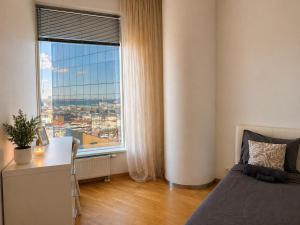a bedroom with a bed and a desk and a window at Panoramic Sea View - 12th floor in Tallinn