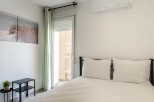 a bedroom with a white bed and a window at Apollo Sea Side Maisonette, Nikiti in Nikiti