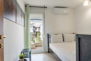 a white bedroom with a bed and a window at Apollo Sea Side Maisonette, Nikiti in Nikiti