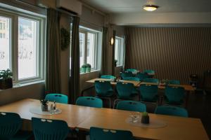 a conference room with tables and chairs and windows at Birkelunden Bed & Breakfast in Rjukan