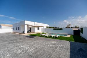 a white building with a patio and an umbrella at Ginebra B BARROSAHOME in Novo Sancti Petri