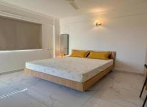 a bedroom with a bed with yellow pillows at HomeSlice Sarjapur - Balcony Rooms in Bangalore