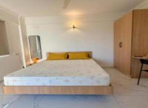 a bedroom with a large bed with yellow pillows at HomeSlice Sarjapur - Balcony Rooms in Bangalore