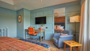 a hotel room with a bed and a desk and a chair at The Great House, Sonning, Berkshire in Reading