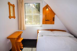 a small bedroom with a bed and a window at Pensiunea HEIDI in Vartop