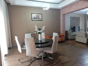 a dining room with a black table and white chairs at Cameo Villa in Kigali