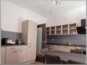 a kitchen with white cabinets and a table with chairs at Fabcap Kapsel Apartment in Halle an der Saale
