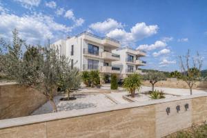 a white building with trees in front of it at Mare Vista Rooftop Penthouse Sea View & Private Jacuzzi in Trogir