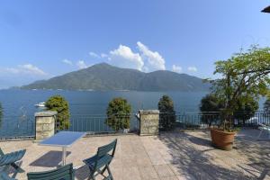 - une table et des chaises sur une terrasse avec vue sur l'eau dans l'établissement Casa la Terrazza sul Lago - WelcHome, à Cannobio