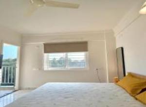 a white bedroom with a bed and a window at HomeSlice Sarjapur - Balcony Rooms in Bangalore +29 photos
